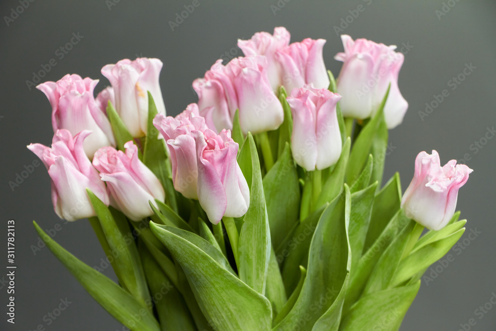 Fototapeta premium Glass vase with pink tulips on a dark wooden table, greeting background or concept