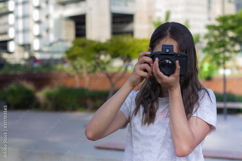 Mujer joven haciendo fotografia en el parque