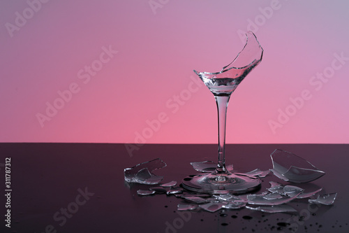 broken wineglass on the table with colored background
