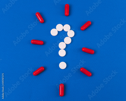 question mark laid out of white tablets on a blue background