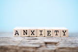 The word anxiety with a wood and light blue background