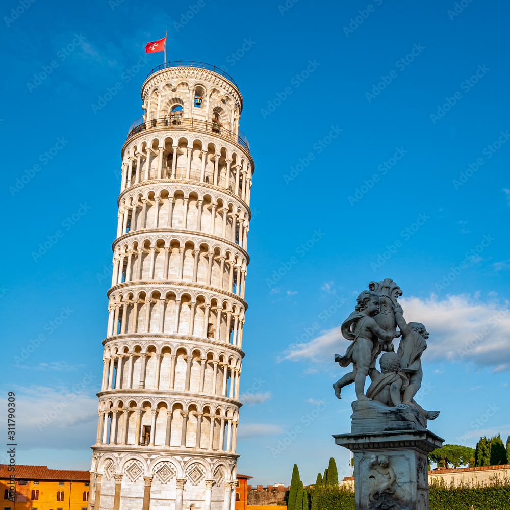 The Leaning Tower and the Putti Fountain, in Piazza dei Miracoli in Pisa. UNESCO world famous site, located in beautiful Tuscany.