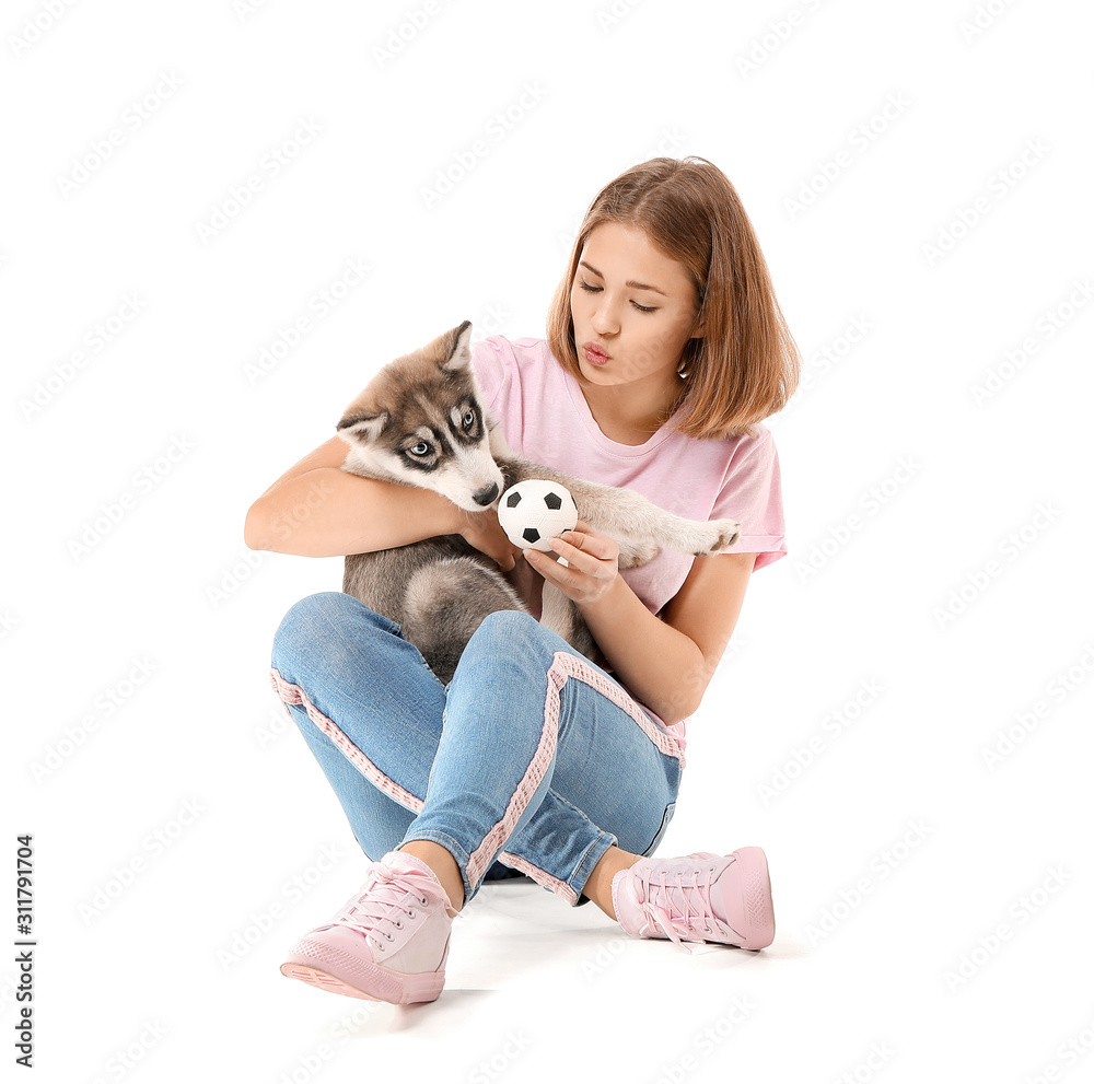 Cute teenage girl playing with funny husky puppy on white background Cute teenage girl playing with funny husky puppy on white background