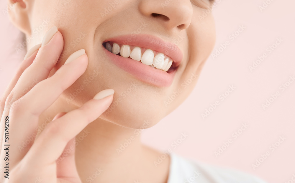 Beautiful young woman with healthy teeth on color background, closeup