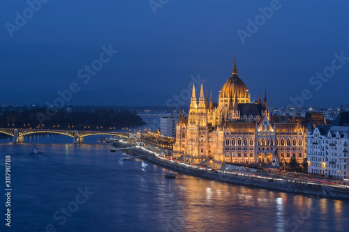 The Hungarian Parliament building illuminated at dusk on the Danube river bank