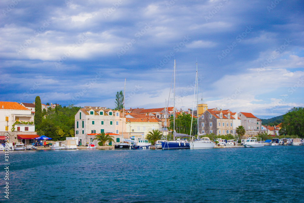 Zlarin, Croatia / 18th May 2019: Seafront view on Zlarin, boats, harbour, Church of Holy Mary