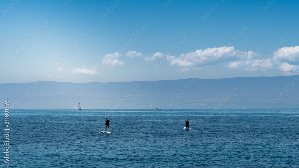 Sailboat and stand up paddle board on Lake Léman, Evian-les-Bains, France