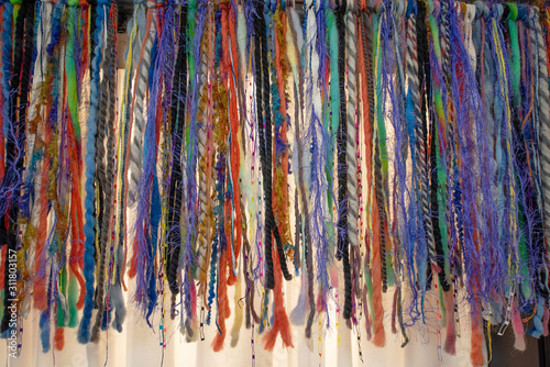 Strands of colorful strings hanging from the ceiling