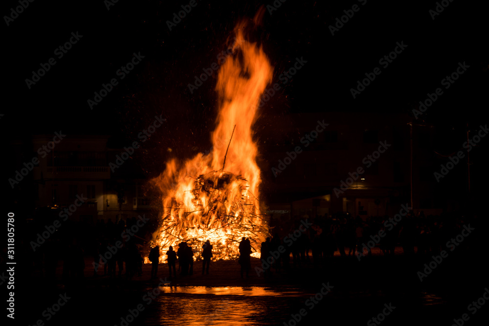 Silhouette of people watching a big bonfire Silhouette of people watching a big bonfire