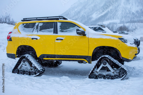 Crawler yellow vehicle direct view in the winter snow