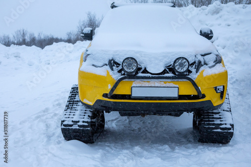 Crawler yellow vehicle direct view in the winter snow