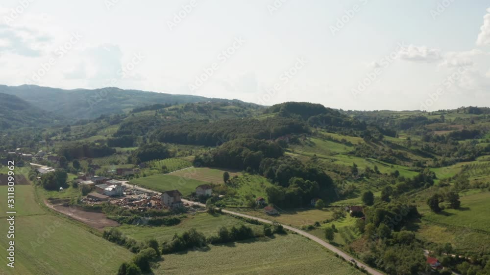 Small agricultural village between two mountains in Bosnia and Herzegovina. Drone top view of green forest and fields in mountain Majevica. Small agricultural village between two mountains in Bosnia and Herzegovina. Drone top view of green forest and fields in mountain Majevica.
