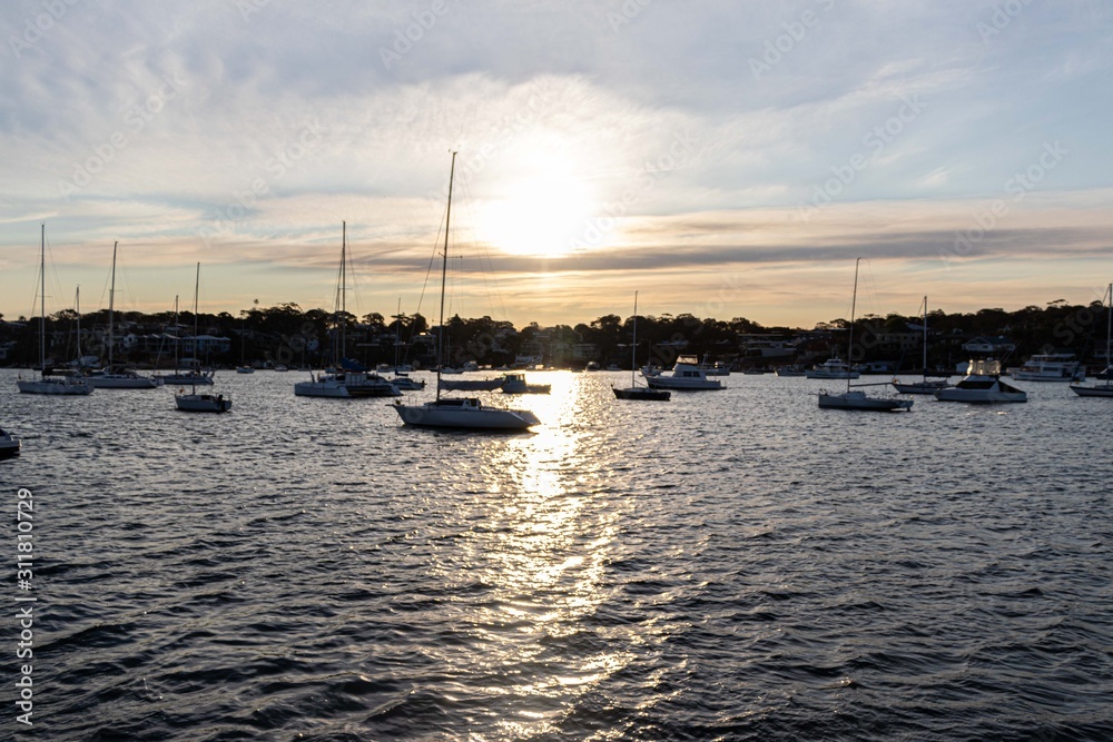 Arm of the sea with yachts and boats standing in the calm water and a beautiful sunset.