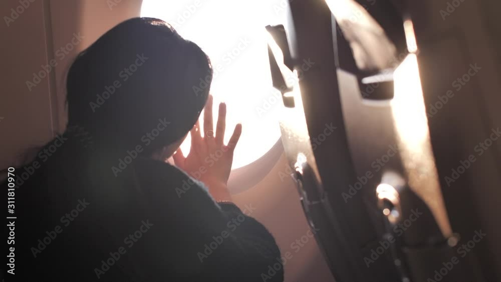 Hand Over Window Girl's hand over the window (illuminator) of an airplane. Sunset light ...