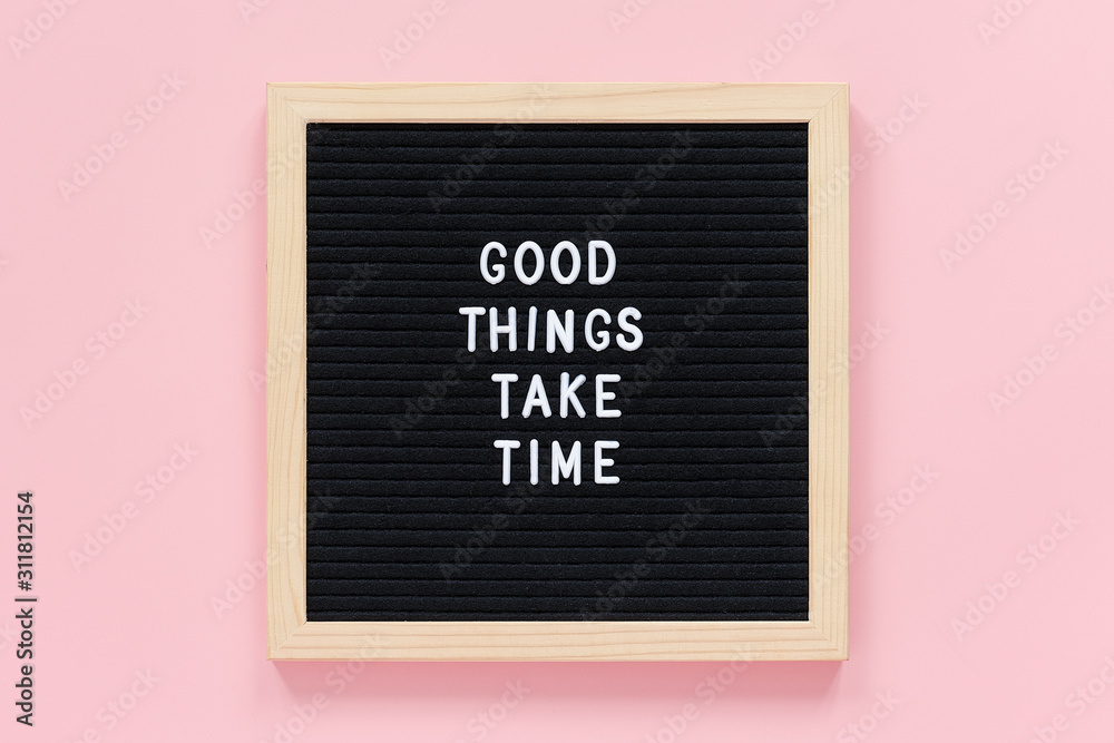 Fototapeta Good things take time. Motivational quote on black letter board on pink background. Concept inspirational quote of the day. Greeting card, postcard Top view Flat lay