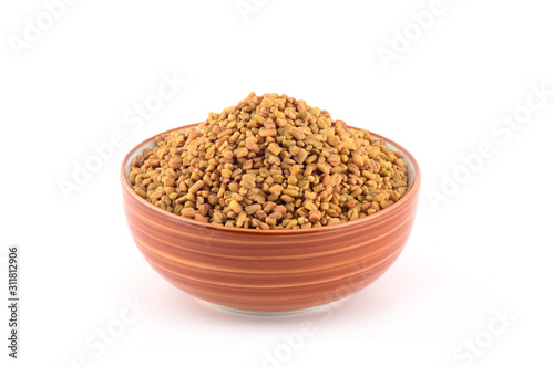 Fenugreek seeds in bowl isolated on white background photo