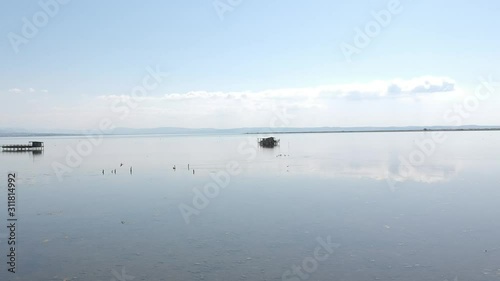 Forward moving drone shot over an ocean towards a fishing shack close to Axios river in Thessaloniki/ Northern Greece photo