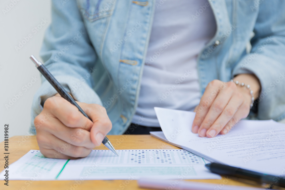 high school,university student study.hands holding pencil writing paper answer sheet.sitting lecture chair taking final exam attending in examination classroom.concept scholarship for education abroad high school,university student study.hands holding pencil writing paper answer sheet.sitting lecture chair taking final exam attending in examination classroom.concept scholarship for education abroad