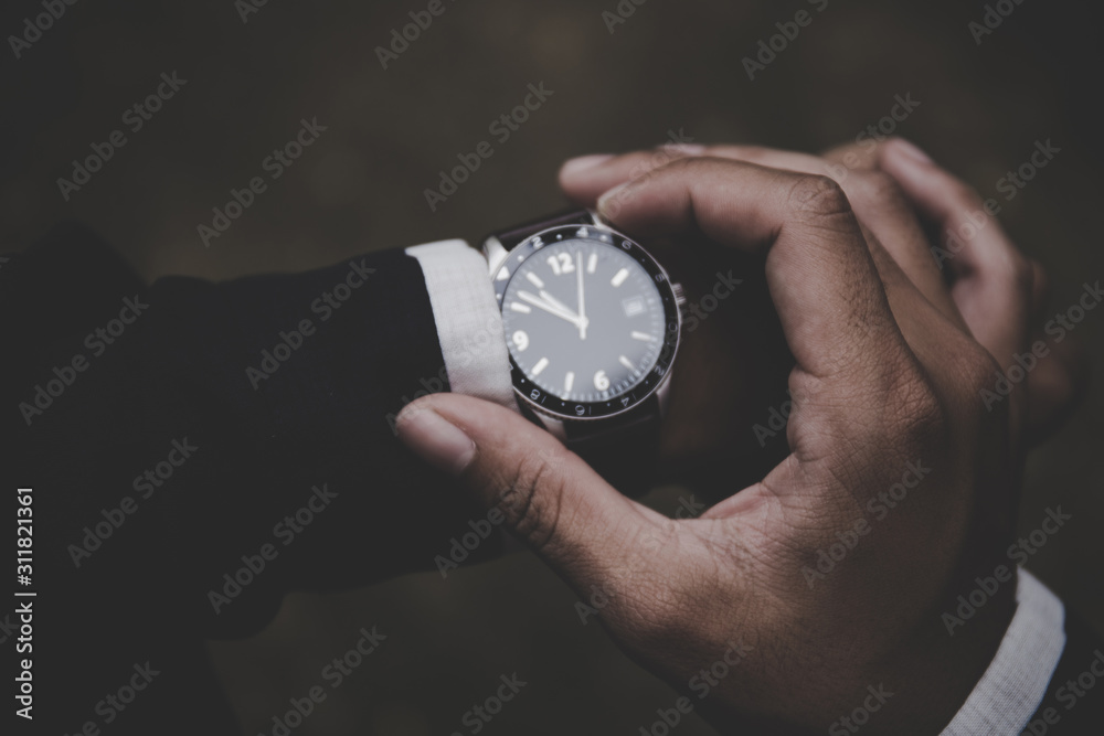 looking at luxury watch on hand check the time.concept for managing time organization working,punctuality,appointment.fashionable wearing stylish looking at luxury watch on hand check the time.concept for managing time organization working,punctuality,appointment.fashionable wearing stylish