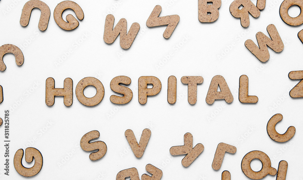 The word hospital among many wooden letters on white background. Top view The word hospital among many wooden letters on white background. Top view