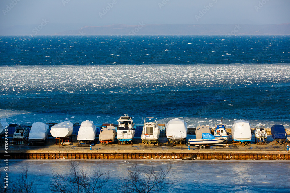 Boat parking in the center of Vladivostok. Boats stand on land during the winter
