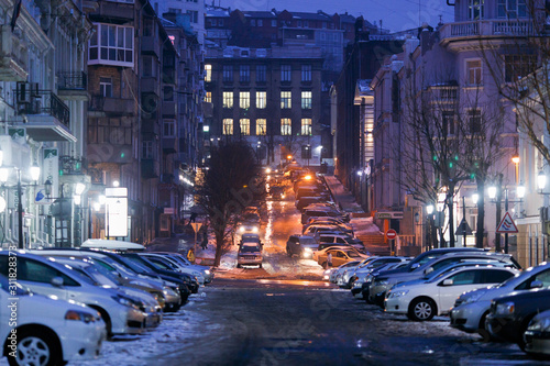 Vladivostok, Russia - Cars drive along central snowy roads. Snowfall in the city.