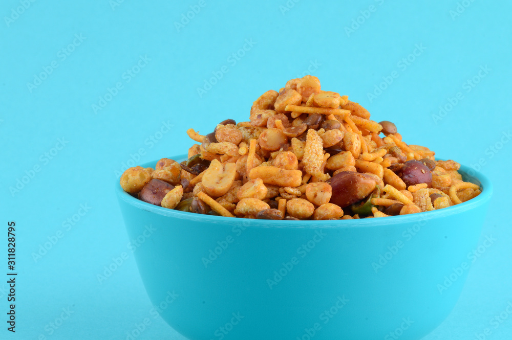 Indian Snacks : Mixture (roasted nuts with salt pepper masala, pulses, channa masala dal green peas) in blue bowl in Indian Snacks : Mixture (roasted nuts with salt pepper masala, pulses, channa masala dal green peas) in blue bowl in