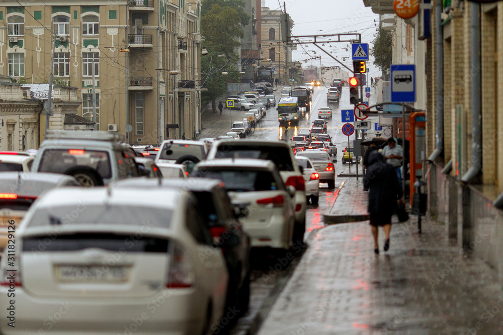 Streets of the city of Vladivostok wet from the rain. People walk along the wet streets of the central part of the city during the rain.