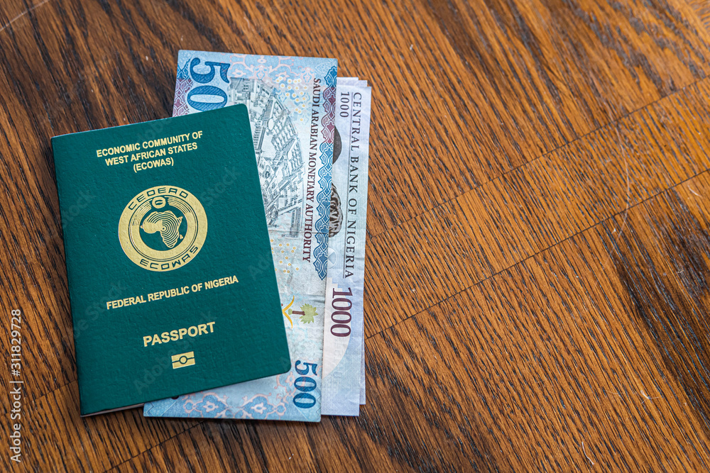 Fototapeta premium Nigerian Passport with Saudi Riyal Banknotes