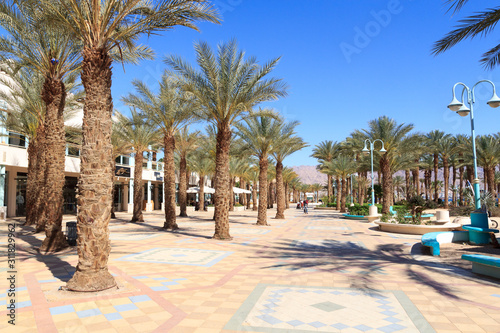 Eilat resort promenade with palm trees and shops, Israel