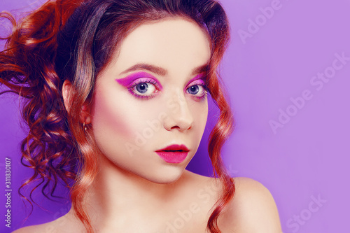 Beautiful young girl with purple make-up, on a purple background. Ideal makeup, eyebrows.