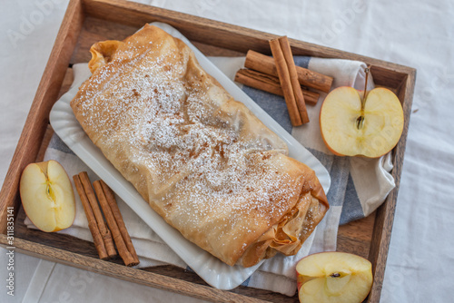 Home made sweet Apple strudel with apples, cinnamon on a table photo