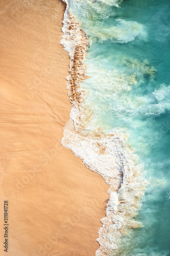 Obraz na płótnie View from above, stunning aerial view of some waves crashing onto a beautiful beach during sunset. Kelingking beach, Nusa Penida, Indonesia. w salonie