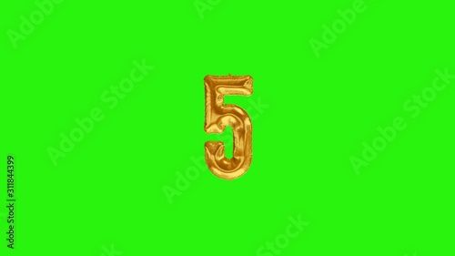 Number 5 five fivth year celebration gold foil balloon floating on green photo