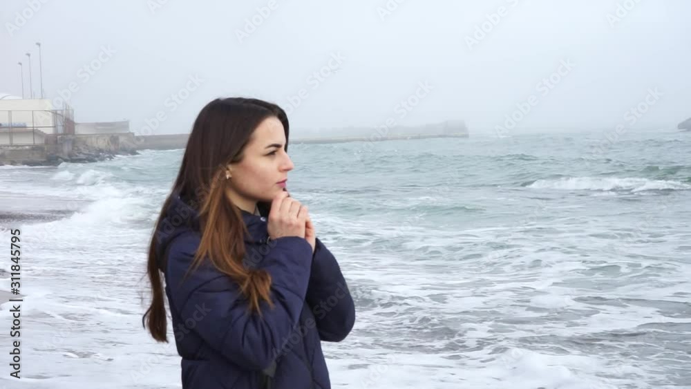 A girl walks along the sea and warms her hands A girl walks along the sea and warms her hands