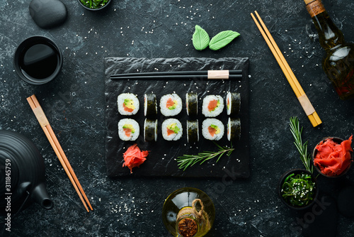 Sushi maki with salmon, avocado and nori. Free space for your text. Japanese Traditional Cuisine. Top view. Rustic style.