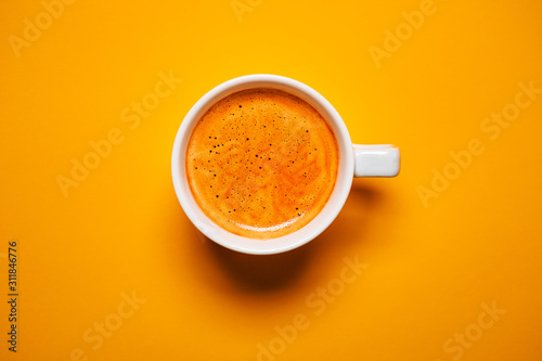 Leinwand Poster Black coffee in a cup on a orange background