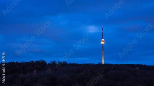 Germany, Blue night sky over famous tv tower building, a skyscraper of stuttgart skyline in the middle of a beautiful forest outside downtown by night