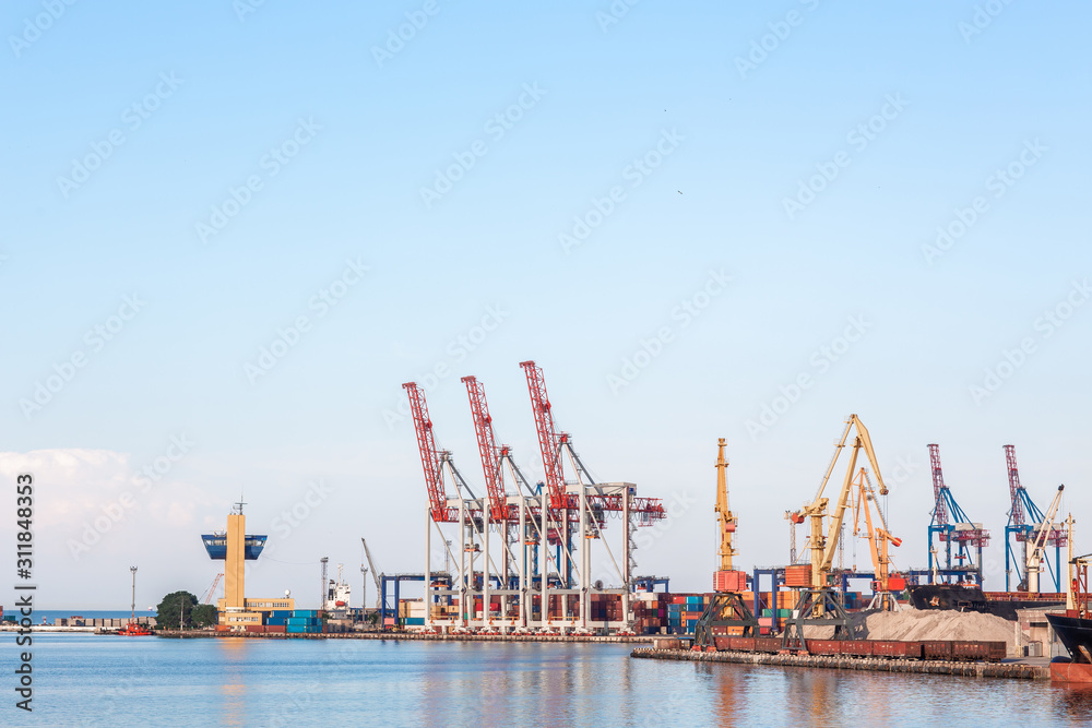 Industrial Container Cargo freight ship with working crane bridge in shipyard at dusk for Logistic Import Export background. port container terminal