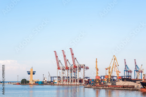 Industrial Container Cargo freight ship with working crane bridge in shipyard at dusk for Logistic Import Export background. port container terminal