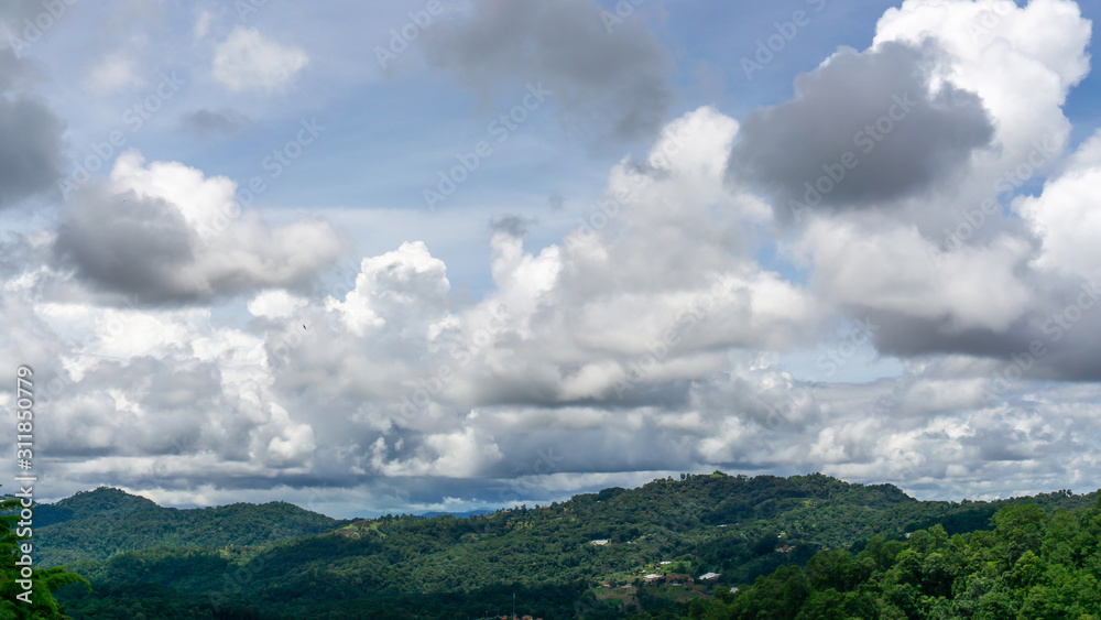 Beautiful view white fluffy clouds on vivid blue sky above greenery mountain
