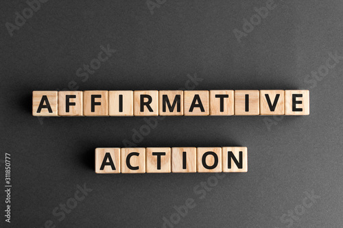 affirmative action- phrase words from wooden blocks with letters, affirmative action support members of a disadvantaged group concept, top view gray background