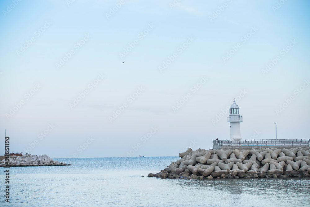 lighthouse. A lighthouse on the coast. A lighthouse on a breakwater. Lighthouse and Tetrapod.