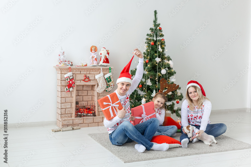 Holidays and presents concept - Portrait of a happy family opening gifts at Christmas time Holidays and presents concept - Portrait of a happy family opening gifts at Christmas time