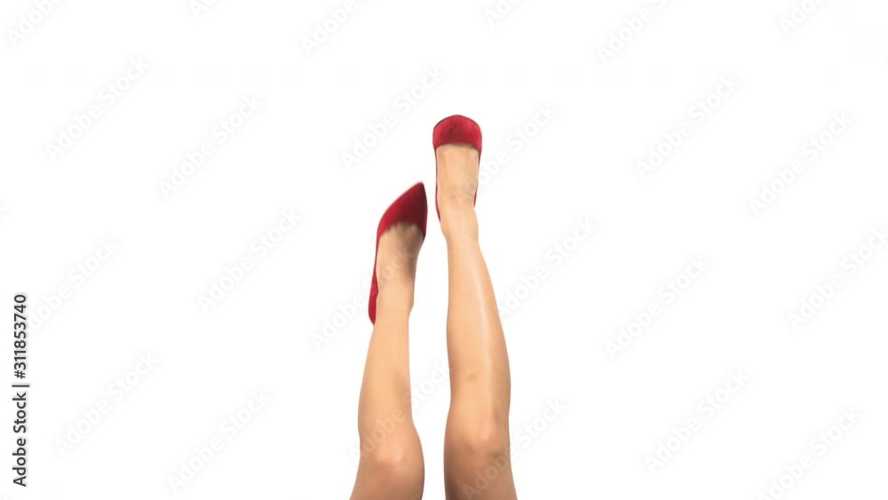 Slim legs in bright red heels. Glossy female shoes. Femininity and chic. Branded footwear of high quality. Slim legs in bright red heels. Glossy female shoes. Femininity and chic. Branded footwear of high quality.