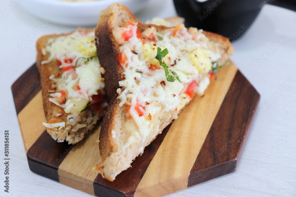 Chili Cheese toast, Open cheese sandwich or mini bread pizzas served with mayonnaise deep and garnished with chopped Basil leaves. Chili Cheese toast, Open cheese sandwich or mini bread pizzas served with mayonnaise deep and garnished with chopped Basil leaves.