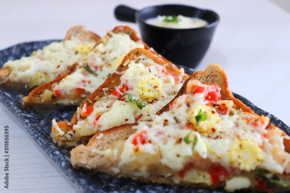 Chili Cheese toast, Open cheese sandwich or mini bread pizzas served with mayonnaise deep and garnished with chopped Basil leaves. Chili Cheese toast, Open cheese sandwich or mini bread pizzas served with mayonnaise deep and garnished with chopped Basil leaves.