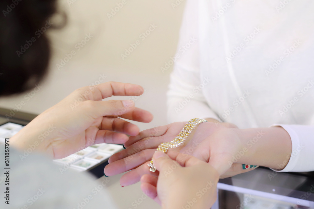 Gemstone bracelet on seller hand while customer try on for buying