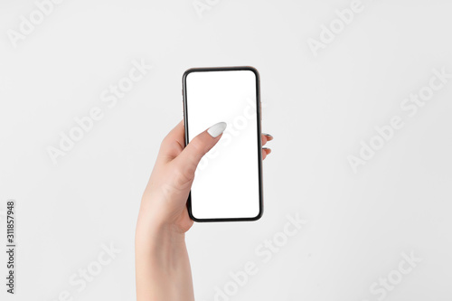 Female hand holding and touching on mobile smartphone with white screen. Isolated on white. Photo template for any images on mobile phone display Layout with easily removable phone monitor background