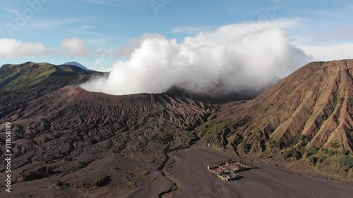 Aerial shot of Mount Bromo landscape, sunny morning light, complete shot of Batok volcano, smoking Bromo and Luhur Poten temple next to the Batok, Java, Indonesia photo